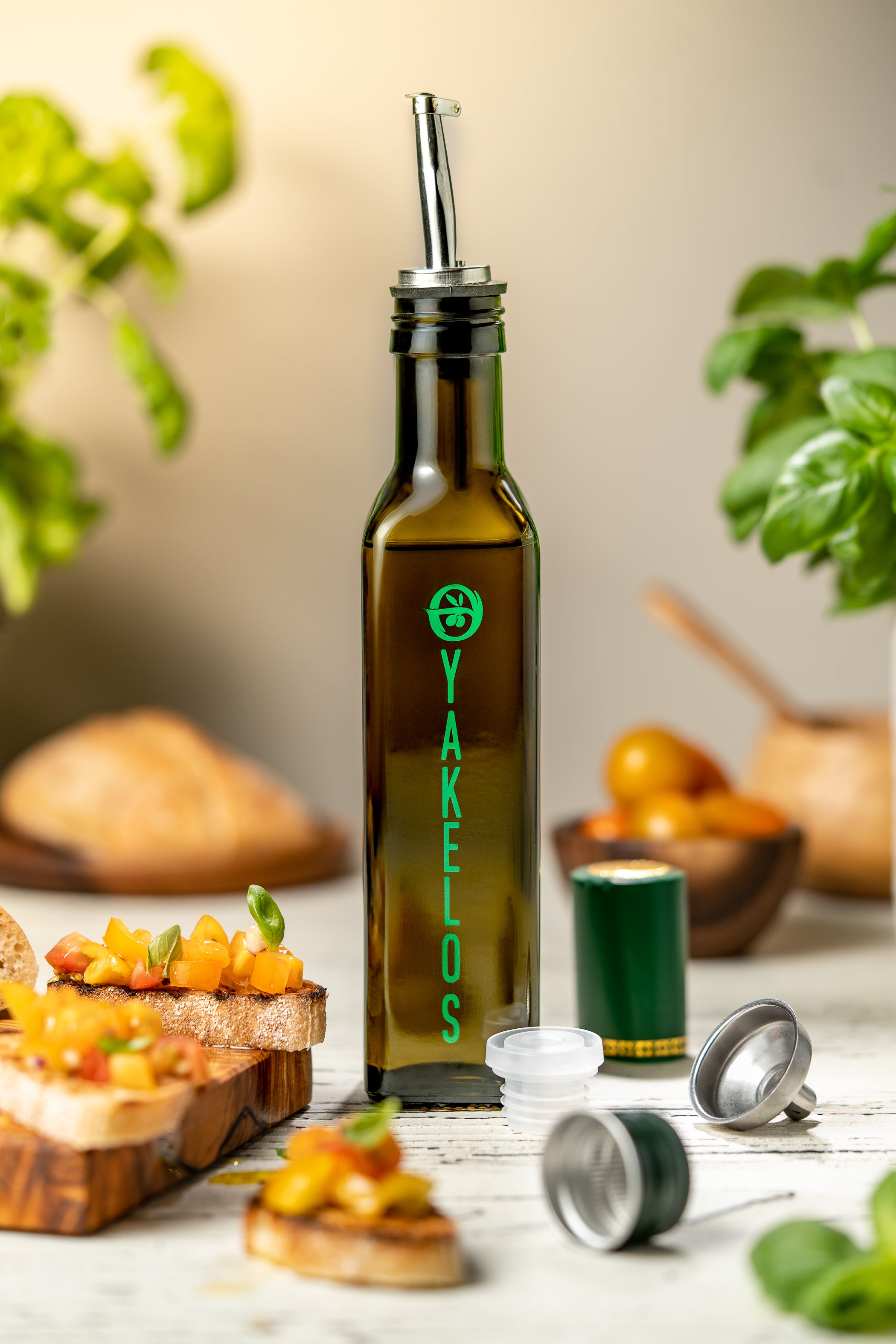 Yakelos olijfolie fles met schenktuit op tafel naast bruschetta met tomaat en basilicum
